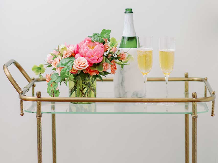 bar cart decorated with pink roses, champagne and flute glasses for valentines day